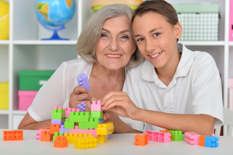 Menino brincando com blocos coloridos de plástico com a avó fotos de stock
