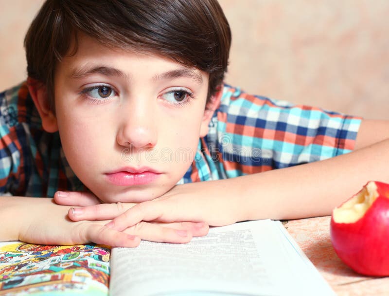 Menino considerável do Preteen com o livro aberto lido imagem de stock Menino considerável do Preteen com o livro aberto lido imagem de stock