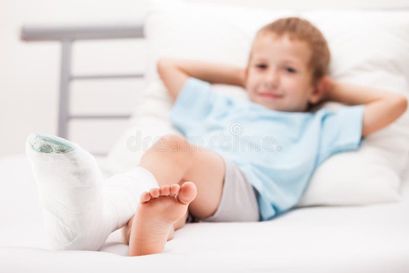 Menino da criança pequena com a atadura do emplastro na fratura ou no Br do salto do pé imagem de stock royalty free Menino da criança pequena com a atadura do emplastro na fratura ou no Br do salto do pé imagem de stock royalty free