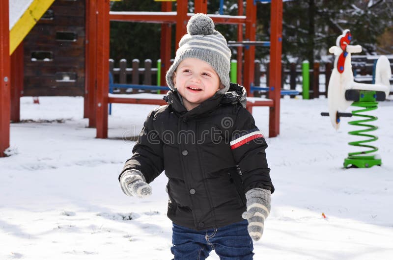 Menino de sorriso bonito que joga com neve imagens de stock Menino de sorriso bonito que joga com neve imagens de stock