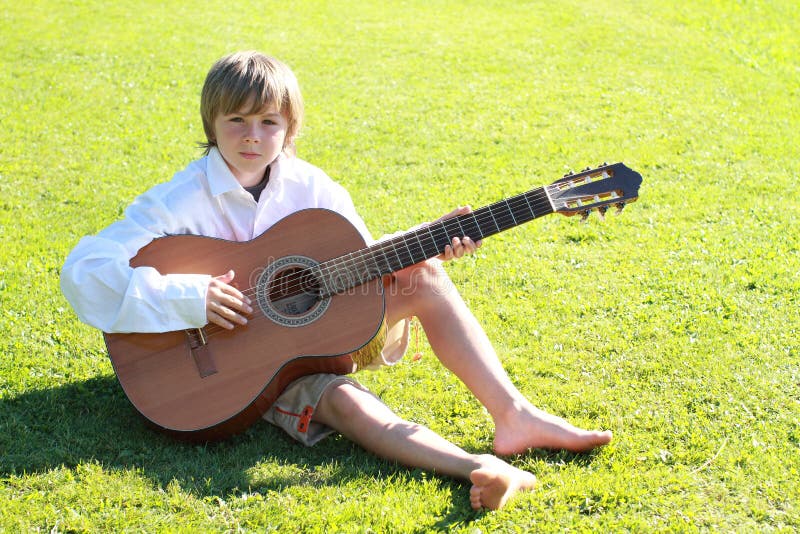 Menino de sorriso com uma guitarra fotos de stock royalty free Menino de sorriso com uma guitarra fotos de stock royalty free