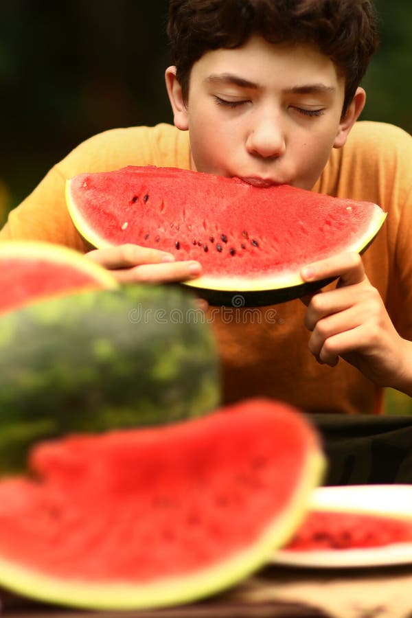 Menino do adolescente com fim cortado da melancia acima da foto imagem de stock Menino do adolescente com fim cortado da melancia acima da foto imagem de stock