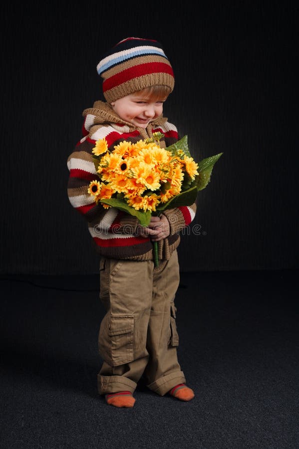 Menino doce pequeno com flores foto de stock royalty free Menino doce pequeno com flores foto de stock royalty free