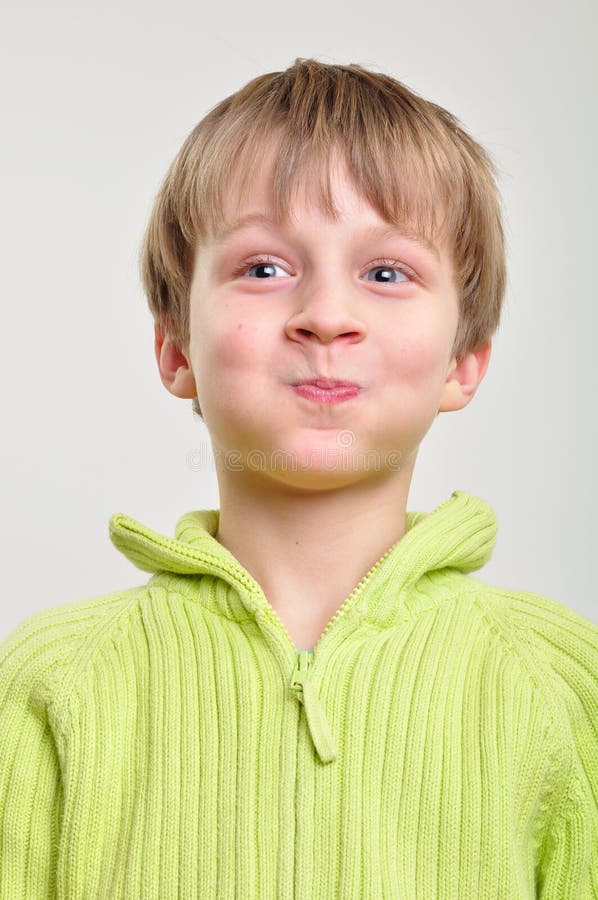 Menino elementar que faz as faces engraçadas imagem de stock royalty free Menino elementar que faz as faces engraçadas imagem de stock royalty free