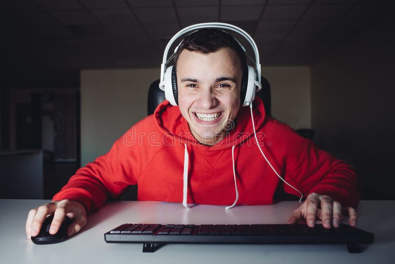 Um menino com fones de ouvido está sentado em um computador