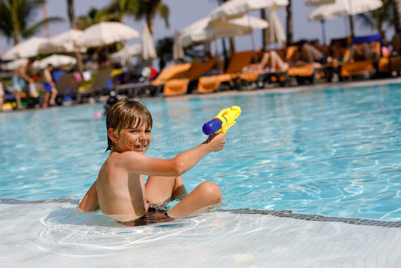Menino feliz da criança que salta na associação e que tem o divertimento em férias em família em um recurso do hotel Criança saud fotos de stock royalty free Menino feliz da criança que salta na associação e que tem o divertimento em férias em família em um recurso do hotel Criança saud fotos de stock royalty free