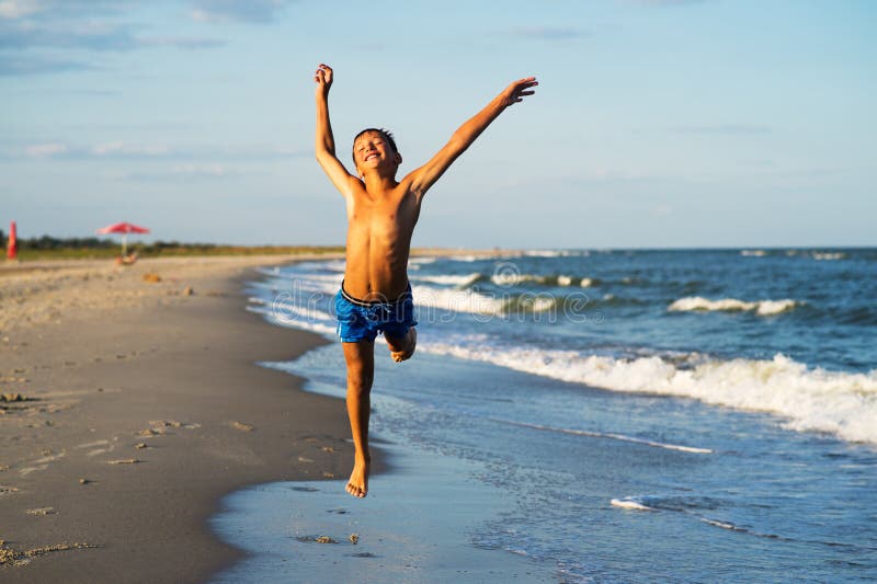 Menino feliz que corre na praia do mar no verão imagem de stock royalty free Menino feliz que corre na praia do mar no verão imagem de stock royalty free