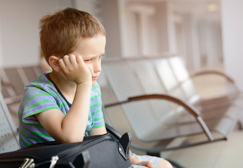 Menino furado da criança que espera no aeroporto imagem de stock Menino furado da criança que espera no aeroporto imagem de stock