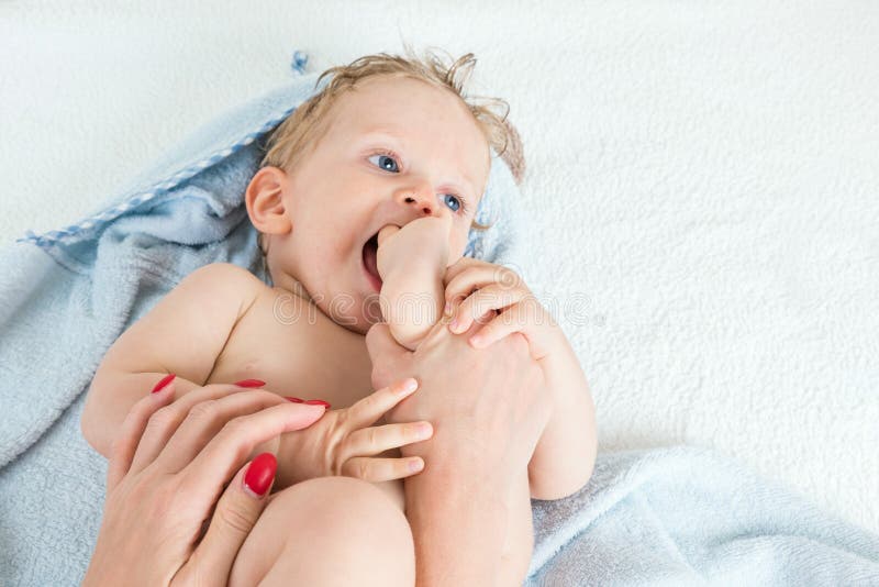 Menino infantil após o banho que joga com seu pé imagens de stock Menino infantil após o banho que joga com seu pé imagens de stock