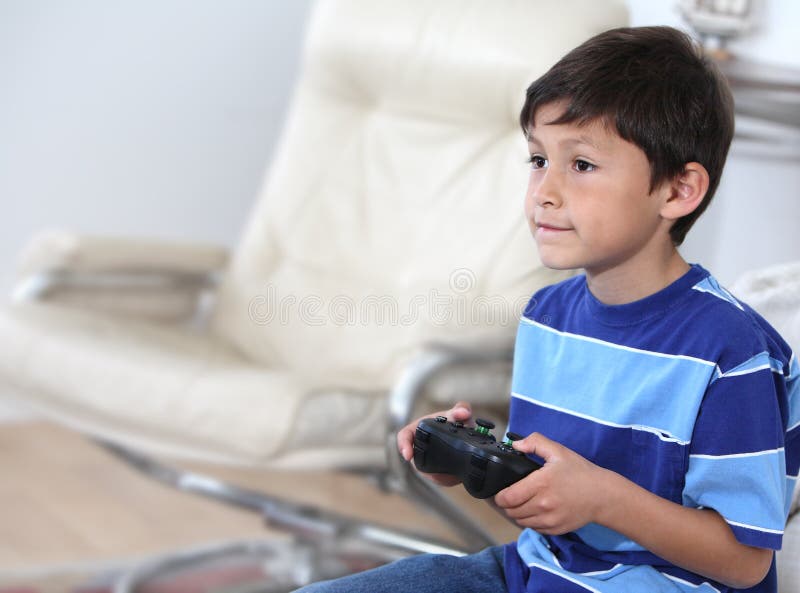 Um menino bonito de 4 anos joga um console de jogos segura um