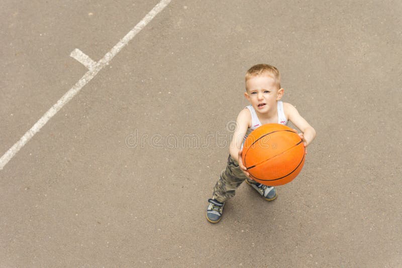 Menino novo bonito que aponta o basquetebol na rede imagens de stock Menino novo bonito que aponta o basquetebol na rede imagens de stock