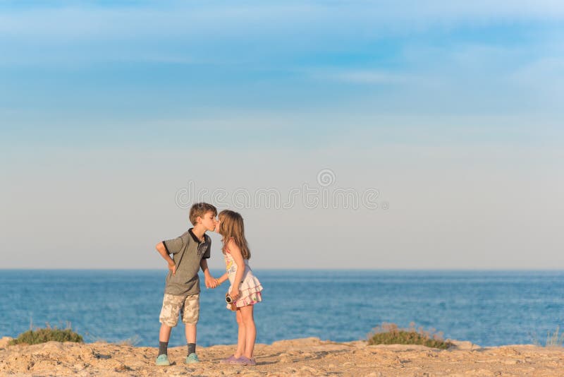 Menino novo que beija uma menina foto de stock Menino novo que beija uma menina foto de stock
