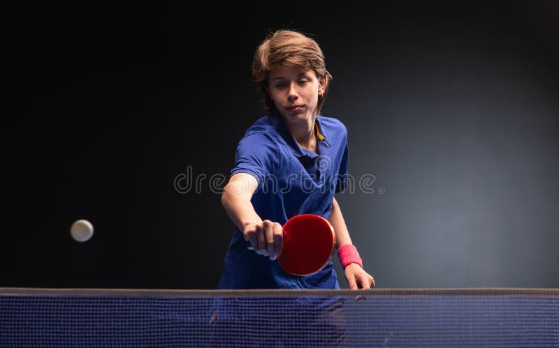 Menino novo que joga o tênis de mesa do pong do sibilo foto de stock Menino novo que joga o tênis de mesa do pong do sibilo foto de stock