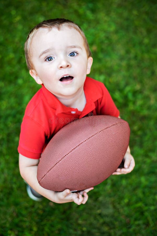 Menino novo que levanta com futebol imagem de stock Menino novo que levanta com futebol imagem de stock