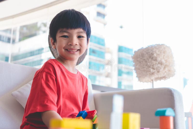 Menino que empilha blocos do brinquedo em uma sala de visitas para o brinquedo educacional fotografia de stock Menino que empilha blocos do brinquedo em uma sala de visitas para o brinquedo educacional fotografia de stock