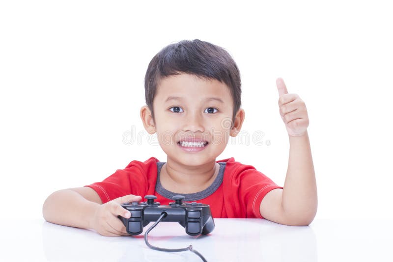 Um menino bonito de 4 anos joga um console de jogos segura um