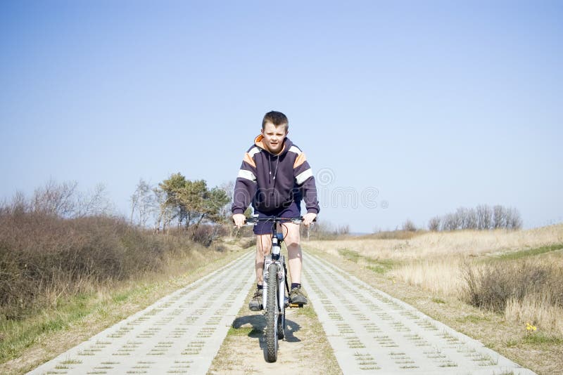 Menino que monta uma bicicleta. fotografia de stock Menino que monta uma bicicleta. fotografia de stock