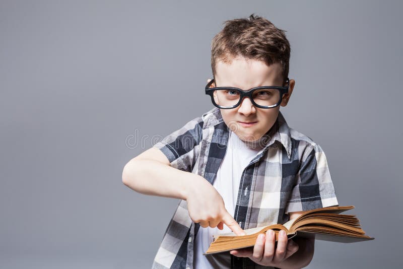 Menino restrito nos vidros com o livro nas mãos, imagens de stock royalty free Menino restrito nos vidros com o livro nas mãos, imagens de stock royalty free