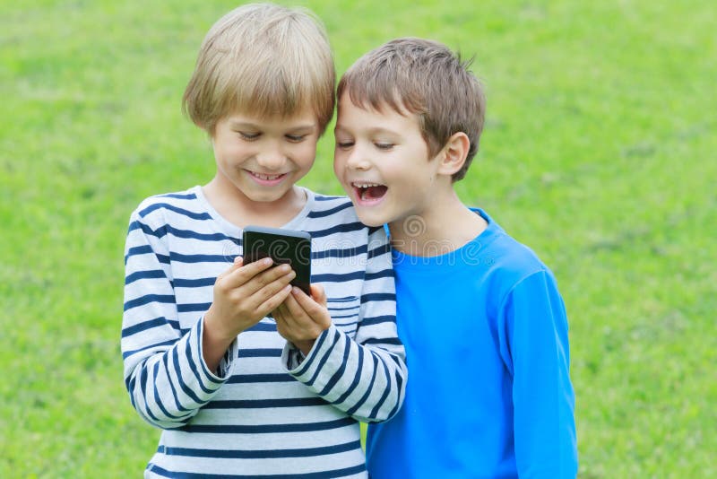 Crianças Com O Telefone Celular Exterior Dois Meninos Que Sorriem