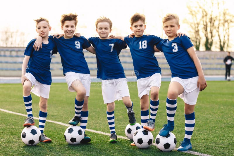 Grupo De Meninos Em Duas Equipes De Futebol De Crianças Competindo Pela  Bola Em Uma Partida De Torneio De Futebol. Crianças Da Escola De Futebol  Que Jogam O Jogo No Campo De