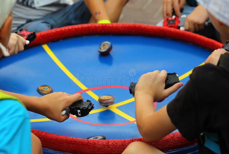 Meninos Que Jogam O Jogo Popular Beyblade Com Partes Superiores De