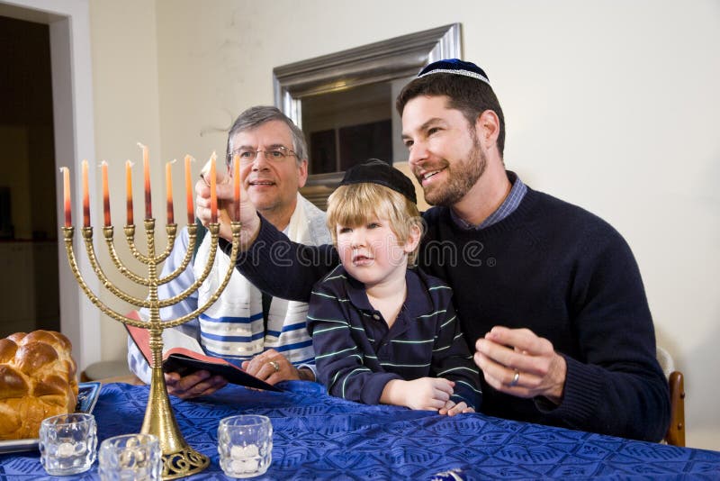 Menorah judaico de Chanukah da iluminação da família fotos de stock Menorah judaico de Chanukah da iluminação da família fotos de stock