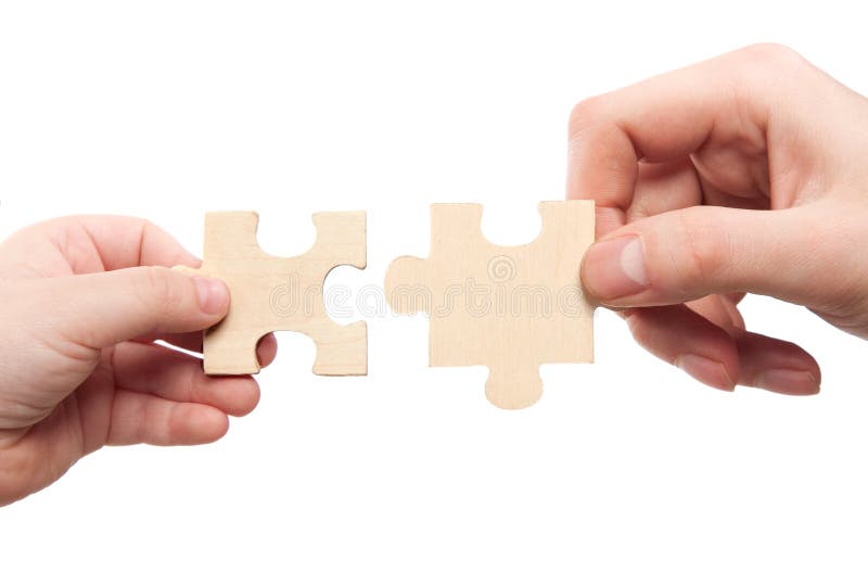 Mens and childs hands connecting puzzles