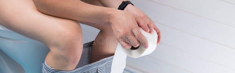 mens in de badkamerszitting op het toilet met zijn ondergoed verwijderd en holding een broodje van toiletpapier royalty-vrije stock fotografie mens in de badkamerszitting op het toilet met zijn ondergoed verwijderd en holding een broodje van toiletpapier royalty-vrije stock fotografie