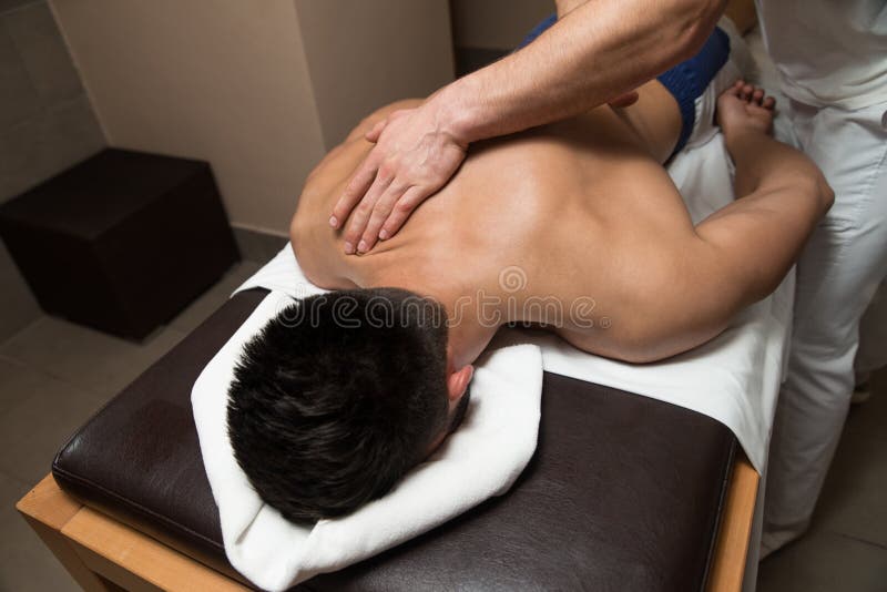 Mens die Achtermassage in een Kuuroordcentrum hebben royalty-vrije stock fotografie Mens die Achtermassage in een Kuuroordcentrum hebben royalty-vrije stock fotografie