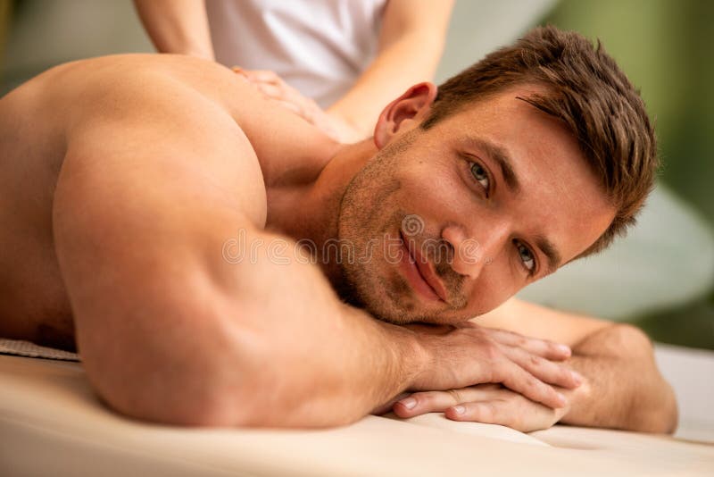 Mens die achtermassage in het gezondheidskuuroord hebben stock afbeelding Mens die achtermassage in het gezondheidskuuroord hebben stock afbeelding