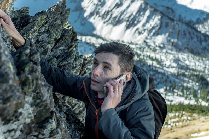 Mens die de berg beklimmen tot de bovenkant en op de telefoon spreken Mededelingen en doelvoltooiing in carrière royalty-vrije stock foto Mens die de berg beklimmen tot de bovenkant en op de telefoon spreken Mededelingen en doelvoltooiing in carrière royalty-vrije stock foto