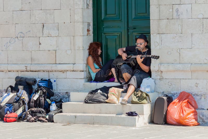 Mens die de gitaar spelen bij de Venetiaanse haven van Chania stock afbeeldingen Mens die de gitaar spelen bij de Venetiaanse haven van Chania stock afbeeldingen