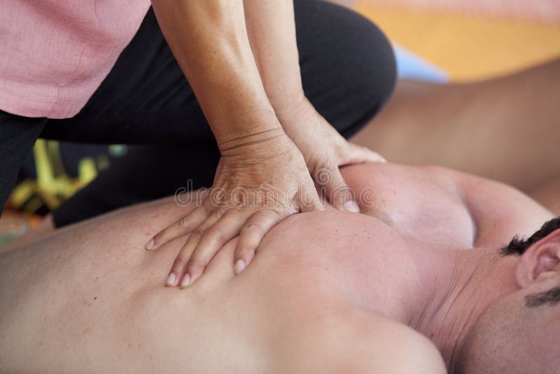 Close-up of an attractive man having a back massage in a spa center. Close-up of an attractive man having a back massage in a spa center