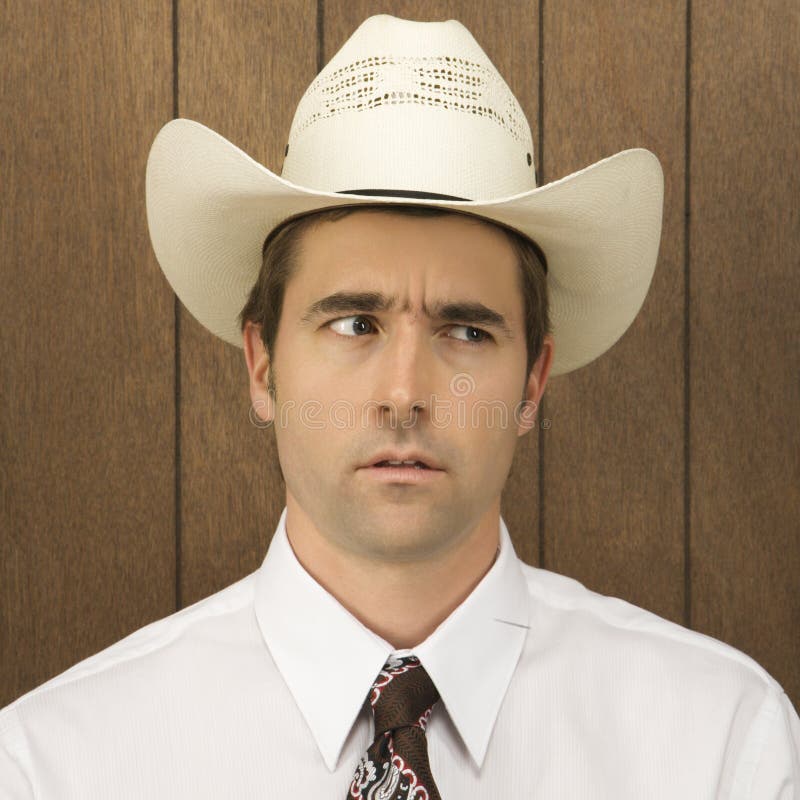 Mens die een cowboyhoed vermindert lookinig aan kant. royalty-vrije stock foto Mens die een cowboyhoed vermindert lookinig aan kant. royalty-vrije stock foto