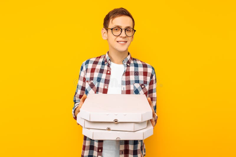 Mens die een doos van pizza op een gele achtergrond houden stock afbeelding Mens die een doos van pizza op een gele achtergrond houden stock afbeelding