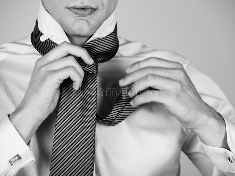 Mens die een gestreepte band in wit overhemd binden royalty-vrije stock afbeeldingen Mens die een gestreepte band in wit overhemd binden royalty-vrije stock afbeeldingen