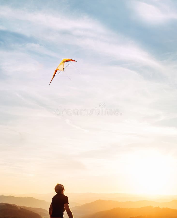 Mens die heldere vlieger in zonsonderganghemel over de berg beginnen te vliegen Succesvol startconceptenbeeld stock fotografie Mens die heldere vlieger in zonsonderganghemel over de berg beginnen te vliegen Succesvol startconceptenbeeld stock fotografie