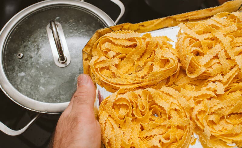 Mens die Italiaanse eideegwaren voorbereidingen treffen te koken stock afbeelding Mens die Italiaanse eideegwaren voorbereidingen treffen te koken stock afbeelding