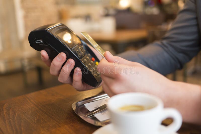 Mens die met NFC-technologie betalen, creditcard, in restaurant, bar