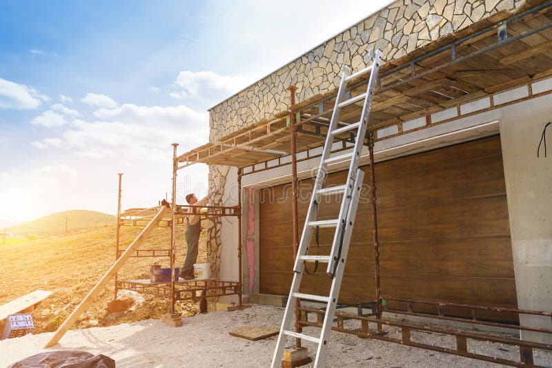 Mens die natuurstenen op een muur zetten stock foto Mens die natuurstenen op een muur zetten stock foto