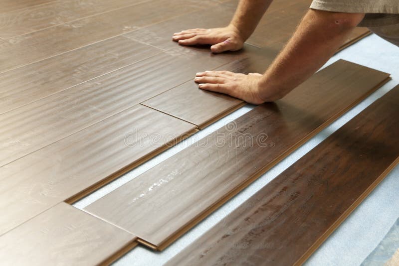 Mens die Nieuwe Gelamineerde Houten Bevloering installeren stock fotografie Mens die Nieuwe Gelamineerde Houten Bevloering installeren stock fotografie