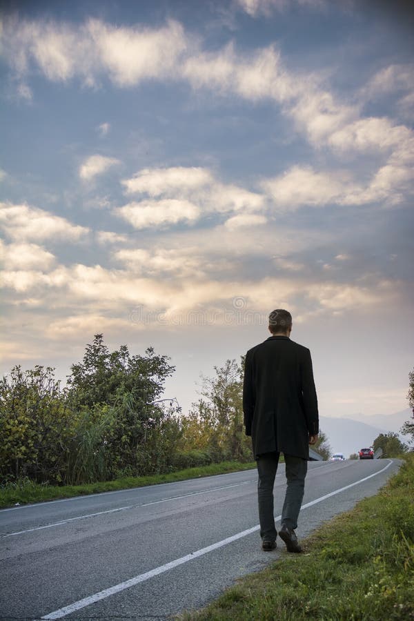 Mens die op kant van de weg lopen stock foto Mens die op kant van de weg lopen stock foto