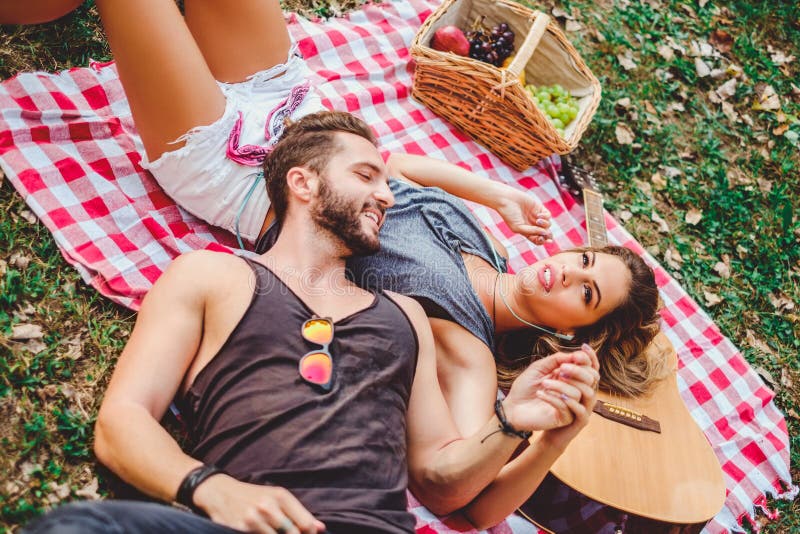 Mens die op meisjesbuik liggen terwijl zij het luisteren muziek is stock foto Mens die op meisjesbuik liggen terwijl zij het luisteren muziek is stock foto