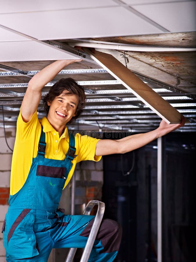 Mens die opgeschort plafond installeren stock foto Mens die opgeschort plafond installeren stock foto
