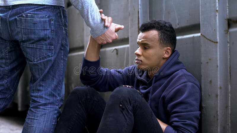 Mens die overgaan door, aanbiedend helpend hand aan straatkind, vriendelijkheid en liefdadigheid royalty-vrije stock afbeeldingen Mens die overgaan door, aanbiedend helpend hand aan straatkind, vriendelijkheid en liefdadigheid royalty-vrije stock afbeeldingen