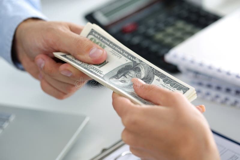 Man taking batch of hundred dollar bills. Hands close up. Man taking batch of hundred dollar bills. Hands close up