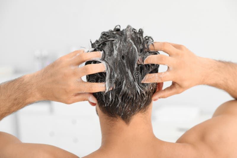 Mens die shampoo op zijn haar toepassen stock afbeelding Mens die shampoo op zijn haar toepassen stock afbeelding