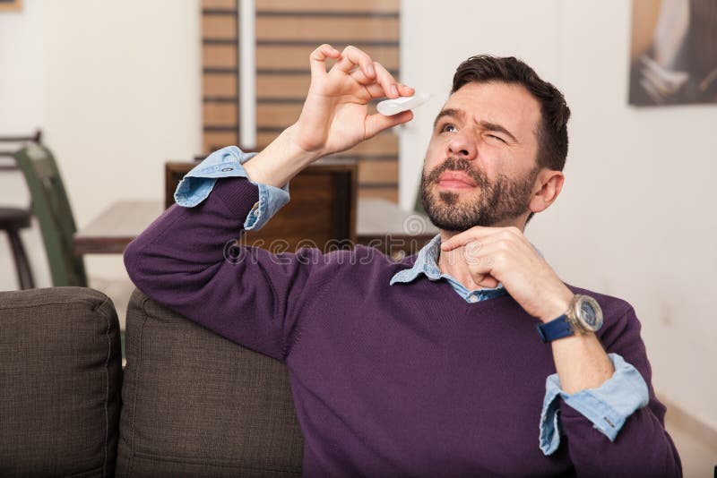 Mens die sommige oogdalingen thuis gebruiken stock foto's Mens die sommige oogdalingen thuis gebruiken stock foto's