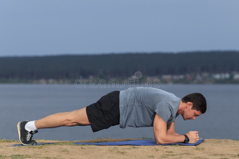 Mens die van de Crossfit de opleidende geschiktheid de oefening doen die van de plankkern zijn midsection kernspieren uitwerken royalty-vrije stock foto Mens die van de Crossfit de opleidende geschiktheid de oefening doen die van de plankkern zijn midsection kernspieren uitwerken royalty-vrije stock foto