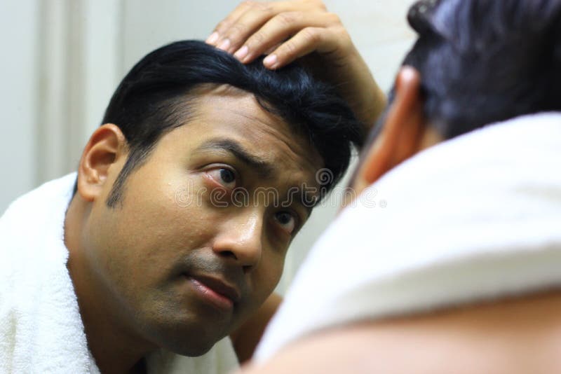 Mens die voor zijn verschijning voor een spiegelschoonheid zorgen die de lifestyleindian Aziatische mens stileren die voor zijn v stock foto's Mens die voor zijn verschijning voor een spiegelschoonheid zorgen die de lifestyleindian Aziatische mens stileren die voor zijn v stock foto's